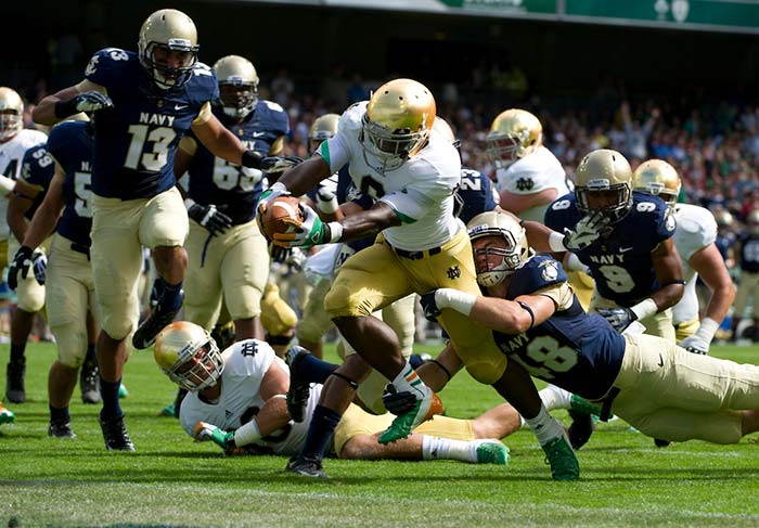 Notre Dame running back Theo Riddick rushes to the end zone for a touchdown as Navy Midshipmen linebacker Keegan Wetzel (48) attempts to tackle during the first quarter the 2012 Emerald Isle Classic at Aviva Stadium in Dublin, Ireland.