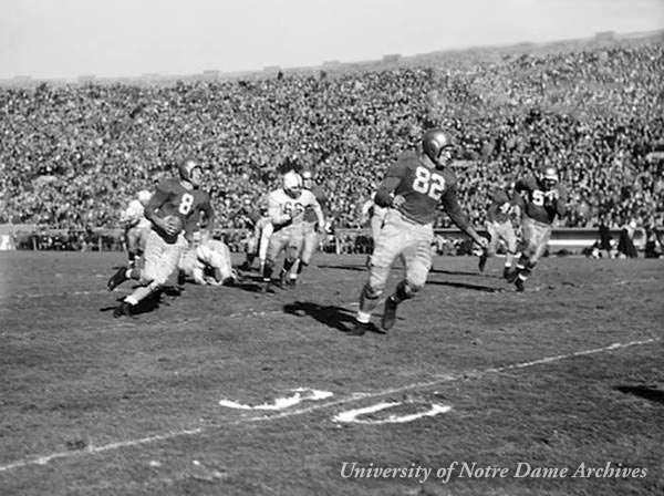Football Game Scene - Notre Dame vs. Washington, 1948. Player Frank Tripucka (#8) running with the ball as Leon Hart (#82) blocks.